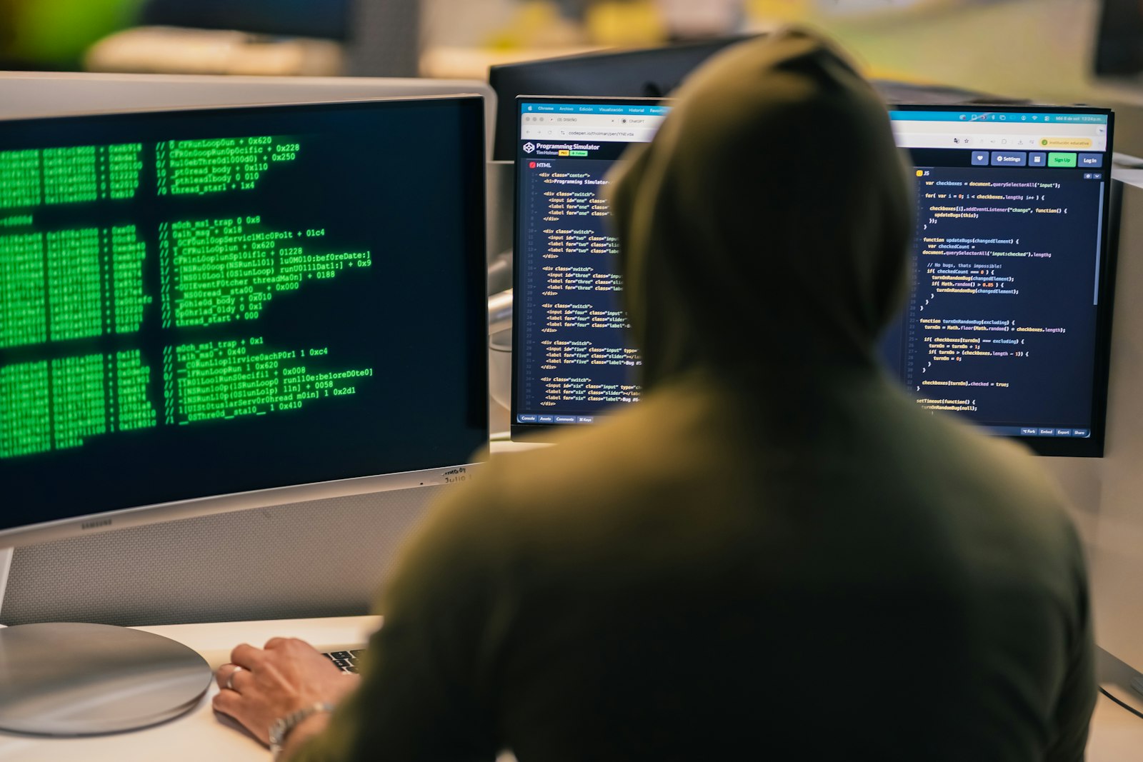 Persoană lucrând la mai multe ecrane de computer