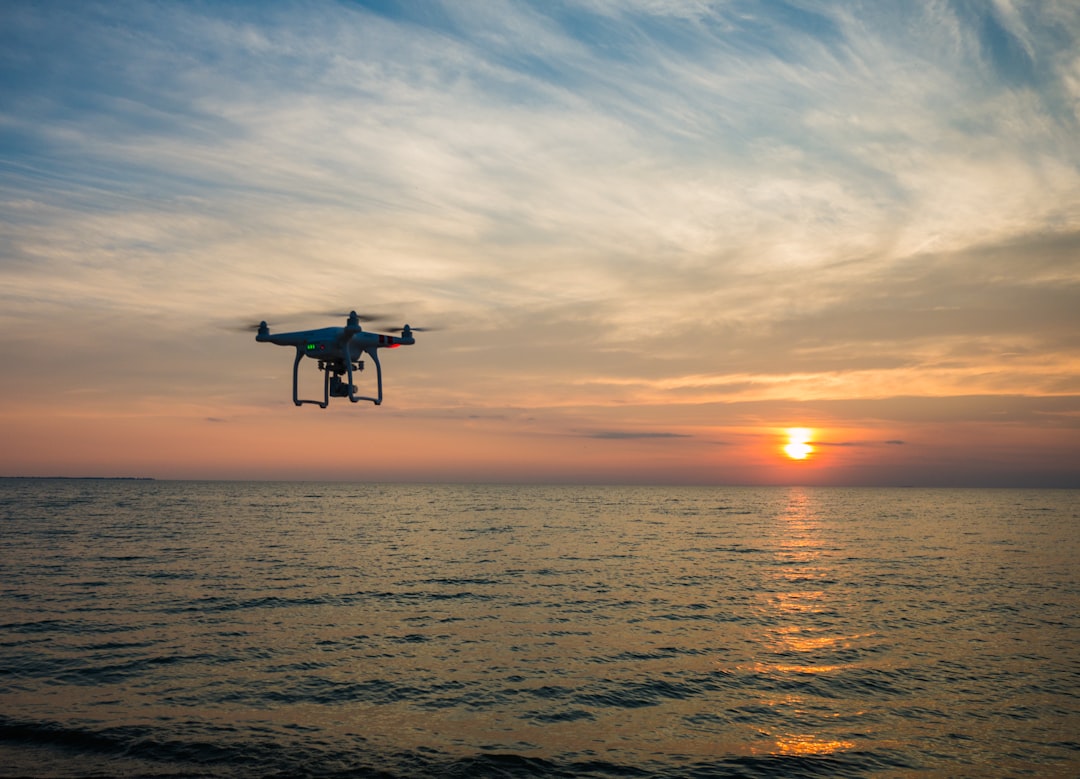 Dronă care zboară deasupra unei întinderi de apă