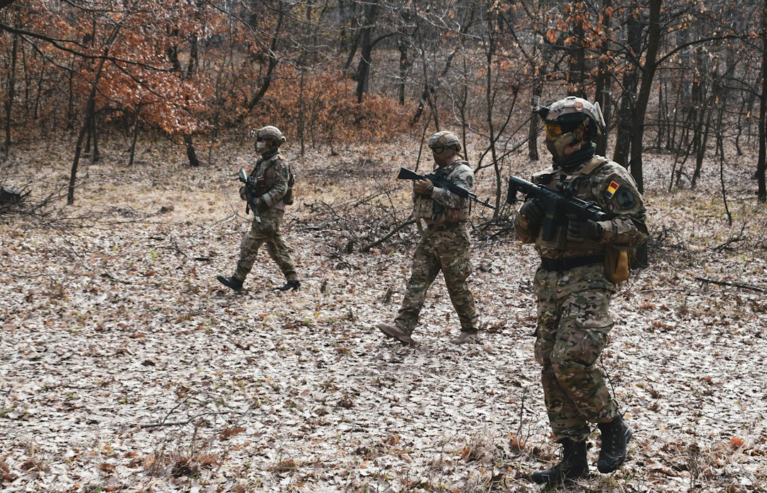 Militari în echipament de luptă, într-o zonă împădurită